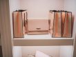 Gorgeous luxury dressing room with pastel puce soft-hued neutral tone brand shopping bags on shelves