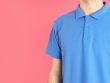 Man in blank blue polo on pink background