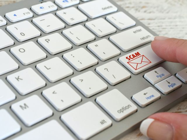 Online Email Scam concept computer keyboard with SCAM email icon symbol about to be opened, no logos