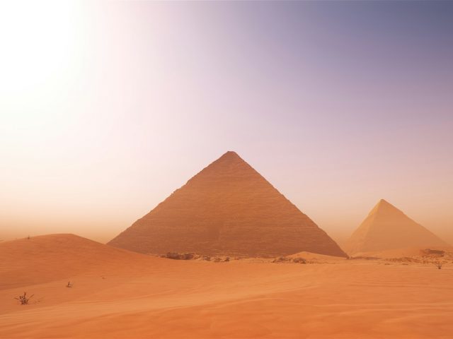 Scenic view of pyramids in the middle desert against a misty sky