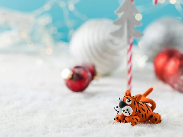 Toy tiger oriental symbol of next year on fake snow against Christmas decor