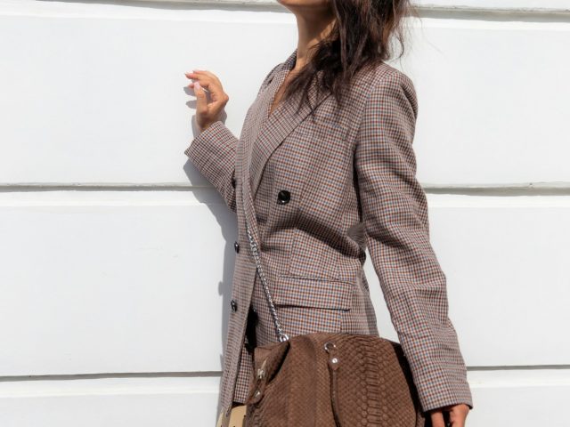 Woman in dress and jacket with brown bag. Fashion street concept.